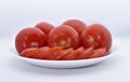 Red tomatoes on a white plate. Sliced tomatoes on a white background. Vegetables on a plate