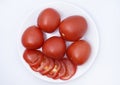 Red tomatoes on a white plate. Sliced tomatoes on a white background. Vegetables on a plate