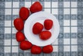 Red tomatoes and white plate on the table