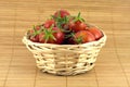 Red tomatoes in wicker basket on straw mat Royalty Free Stock Photo