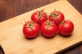 Red tomatoes on a wooden background