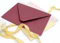 Red-tone paper envelopes with ribbon on a white background