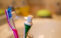 red toothbrush, green toothpaste and white sink