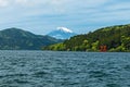 Red torii gate on the shore of Lake Ashi, near Mount Fuji in Hak