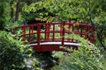 Red Torii gates and lacquered arched bridge in a Japanese zen  gardens Royalty Free Stock Photo