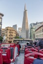 Red tourist bus riding in San Francisco under a blue sky with modern skyscrapers around it Royalty Free Stock Photo