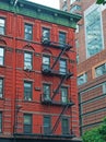 Red townhouse with emergency stairs in Soho, New York, skyline