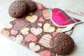 Red toy bird and cookies on dark napkin with image of hearts