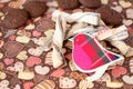 Red toy bird and cookies on dark napkin with image of hearts