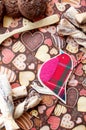 Red toy bird and cookies on dark napkin with image of hearts Royalty Free Stock Photo