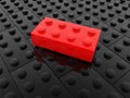 Red toy brick over black toy bricks Royalty Free Stock Photo