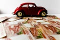 Red toy car on the background of Russian money bills. Buying a new car on credit and by installments.Russian banknotes