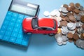 Red toy car, calculator and coins on the blue background Royalty Free Stock Photo