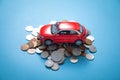 Red toy car and coins on the blue background Royalty Free Stock Photo