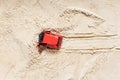Red toy car dug in the sand, quicksand. wheel tracks in the sand. difficult situation Royalty Free Stock Photo