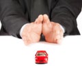 Red toy car in front of businessman, concept for insurance, buying, renting, fuel or service and repair costs Royalty Free Stock Photo