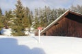 Red toy car infront of snowy hut and forest landscape