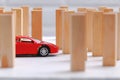 Red toy car overcomes all obstacles and barriers reaching the goal.