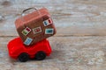 red toy car with suitcases on a wooden background. Travel concept. With copy space Royalty Free Stock Photo