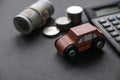 A red toy car together with coins, money and calculator on a black background Royalty Free Stock Photo