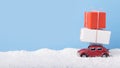Red toy car Volkswagen Beetle with big gift boxes on background with snow Royalty Free Stock Photo