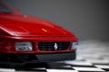 Red toy Ferrari 348TB sports car close up product shot on a chequered ground and gray background Royalty Free Stock Photo