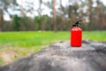 Red toy fire extinguisher on a burnt tree stump Royalty Free Stock Photo