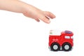 Red toy firefighter car with kid hand, isolated on white background, fire truck engine Royalty Free Stock Photo