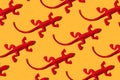 red toy lizards on a yellow background. wild nature pattern