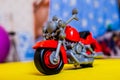 Red toy motorcycle on a blurry background.