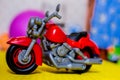 Red toy motorcycle on a blurry background.