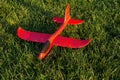 Red toy plane lying on the grass Royalty Free Stock Photo