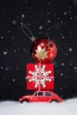 Red toy retro car carries on a roof a Christmas gift and Christmas ball Royalty Free Stock Photo