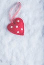 Red toy suave heart on a frosty white snow background. Love and St. Valentine concept.