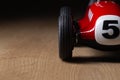 Red toy vintage racing car close up still detail on a wooden surface Royalty Free Stock Photo