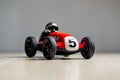 Red toy vintage racing car close up still with plate with number five painted on it Royalty Free Stock Photo