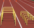 Different sized plastic yellow hurdles on a track with orange cones in the distance