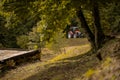 Red tractor approaching the camera on a small gravel road in the forest, manouvering around tight corners and bends. Forest Royalty Free Stock Photo