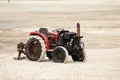 Red tractor on the beach sand Royalty Free Stock Photo