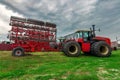 red tractor. farming machinery wheeled tractor on a green grass over farm