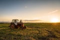 Red tractor on golden sunset sky Royalty Free Stock Photo