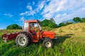 Red tractor in a mountain meadow Royalty Free Stock Photo