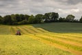 Landscape with red tractor mowing on hilly Irish farm