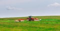 A red tractor mows the grass on a farmer's field. Two mowers will mow a large area of the field. Royalty Free Stock Photo