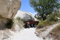 Red tractor on a narrow sandy path between rocks in the countryside in Cappadocia, Turkey