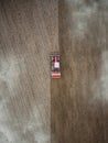 Red tractor plowing farm field aerial view looking down from above through clouds. Drone photo cultivation machine equipment work Royalty Free Stock Photo