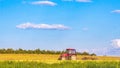 Red tractor plows a field on a summer day. Working day in agriculture Royalty Free Stock Photo