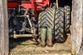 Red tractor and rubber boots in wooden barn