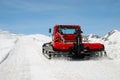 Red tractor on snow slope