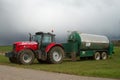 Red tractor and tanker in field